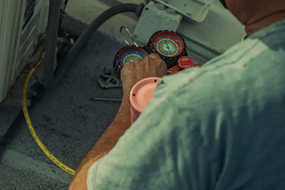 Technician reading refrigerant gauges