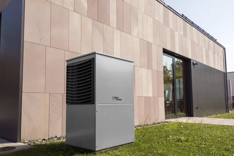 After: a heat pump outdoor unit beside a house