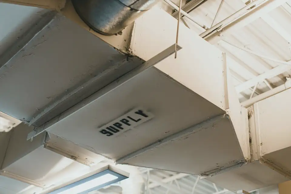Close view of a metal supply air duct labelled supply